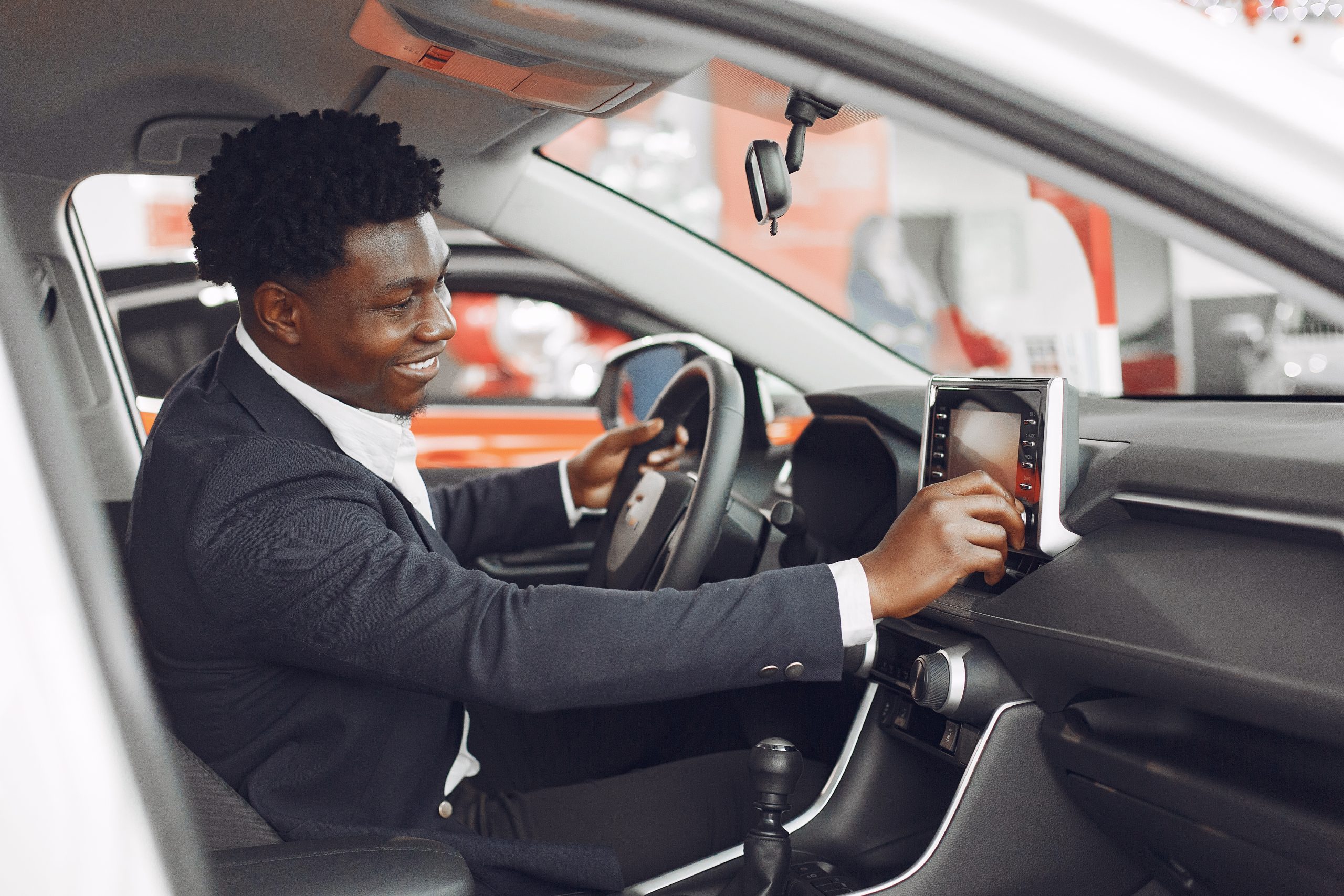 british car transfer driver adjusting volume of a speaker in a car